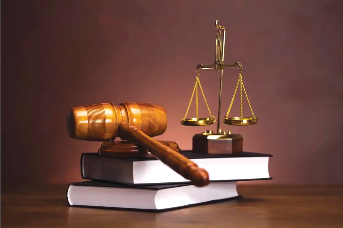 Marteau de juge et balance de la justice posés sur des codes juridiques